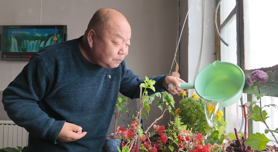 12月25日，赵兴盛在家中浇花。于三 摄