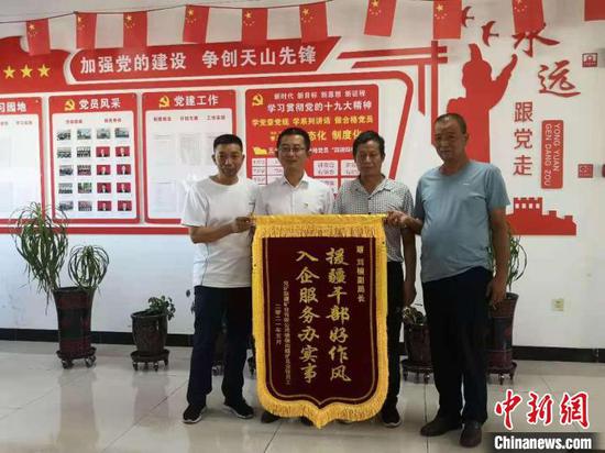 因帮企业解决职工退休时遇到的历史遗留问题，山西援疆干部刘楠获赠锦旗。　范丽芳 摄