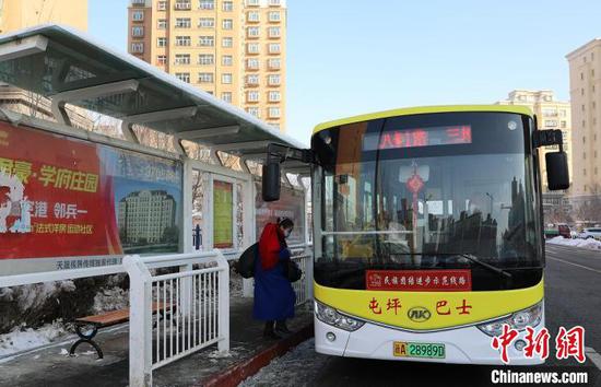 公交车到站，乘客上车。　冯晓玲 摄