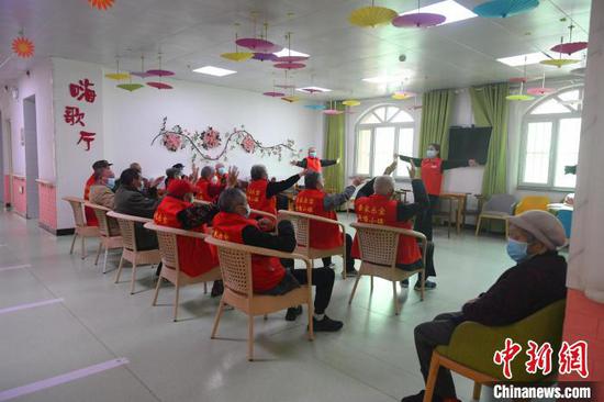 社工赫丽米古丽·艾散正在带老人做康复娱乐活动。　李芸 摄