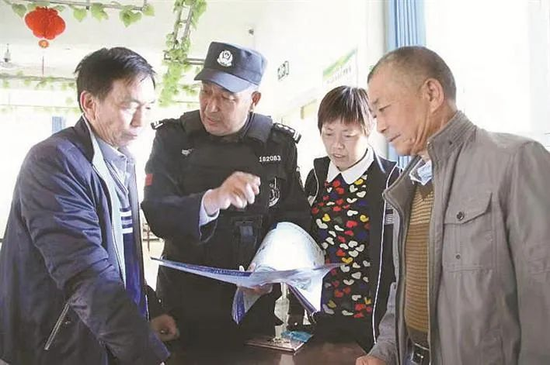 李玉山(左二)向辖区居民发放安全宣传手册并普及相关知识(资料图片)。 李玉山(左二)向辖区居民发放安全宣传手册并普及相关知识(资料图片)。