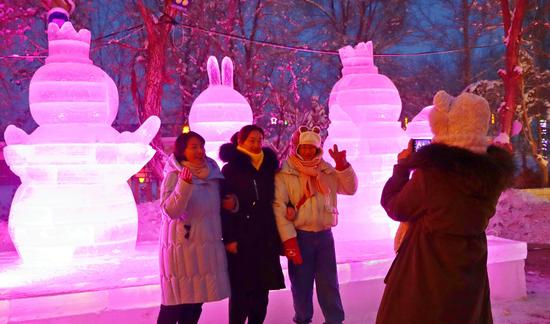 游客在芳草东湖景区观赏冰雕，拍照打卡。胡阿尼西·巴合提 摄