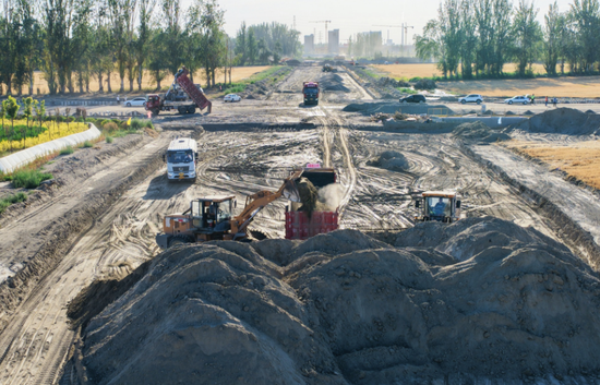 图为多台工程机械紧张作业，一派繁忙有序的施工景象。李桃 摄